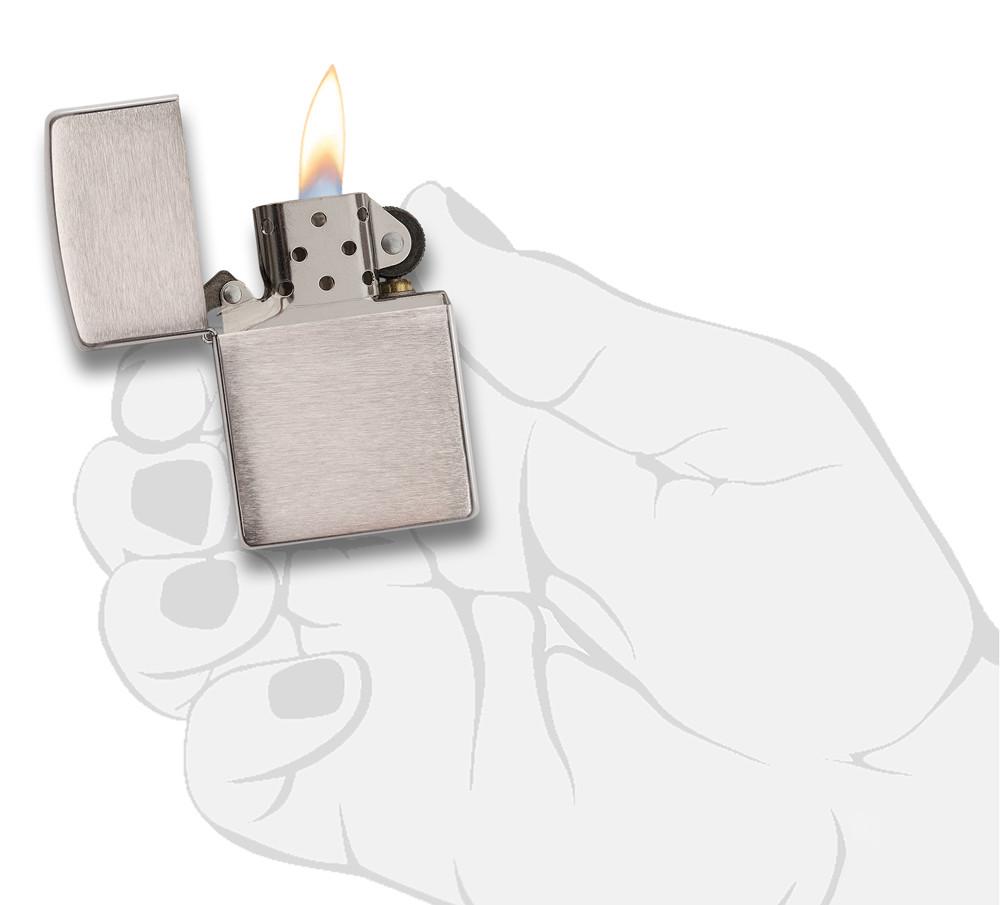 Vue de face briquet Zippo Chrome Brushed modèle de base, ouvert avec flamme dans une main stylisée