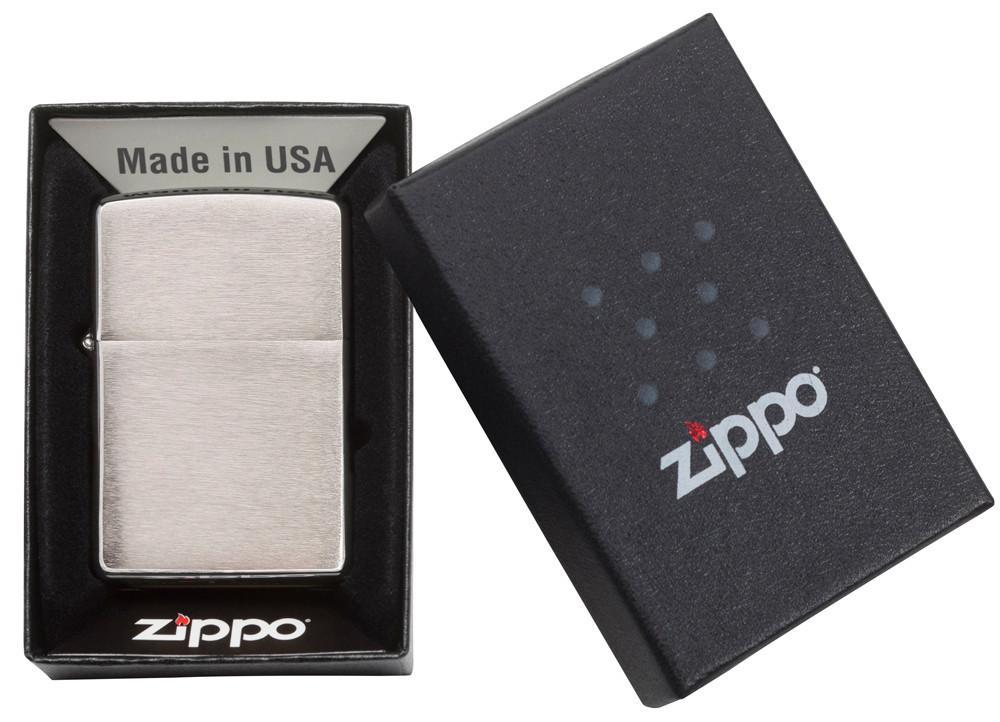 Vue de face briquet Zippo Brushed  Chrome modèle de base, ouvert avec flamme dans une boîte cadeau ouverte